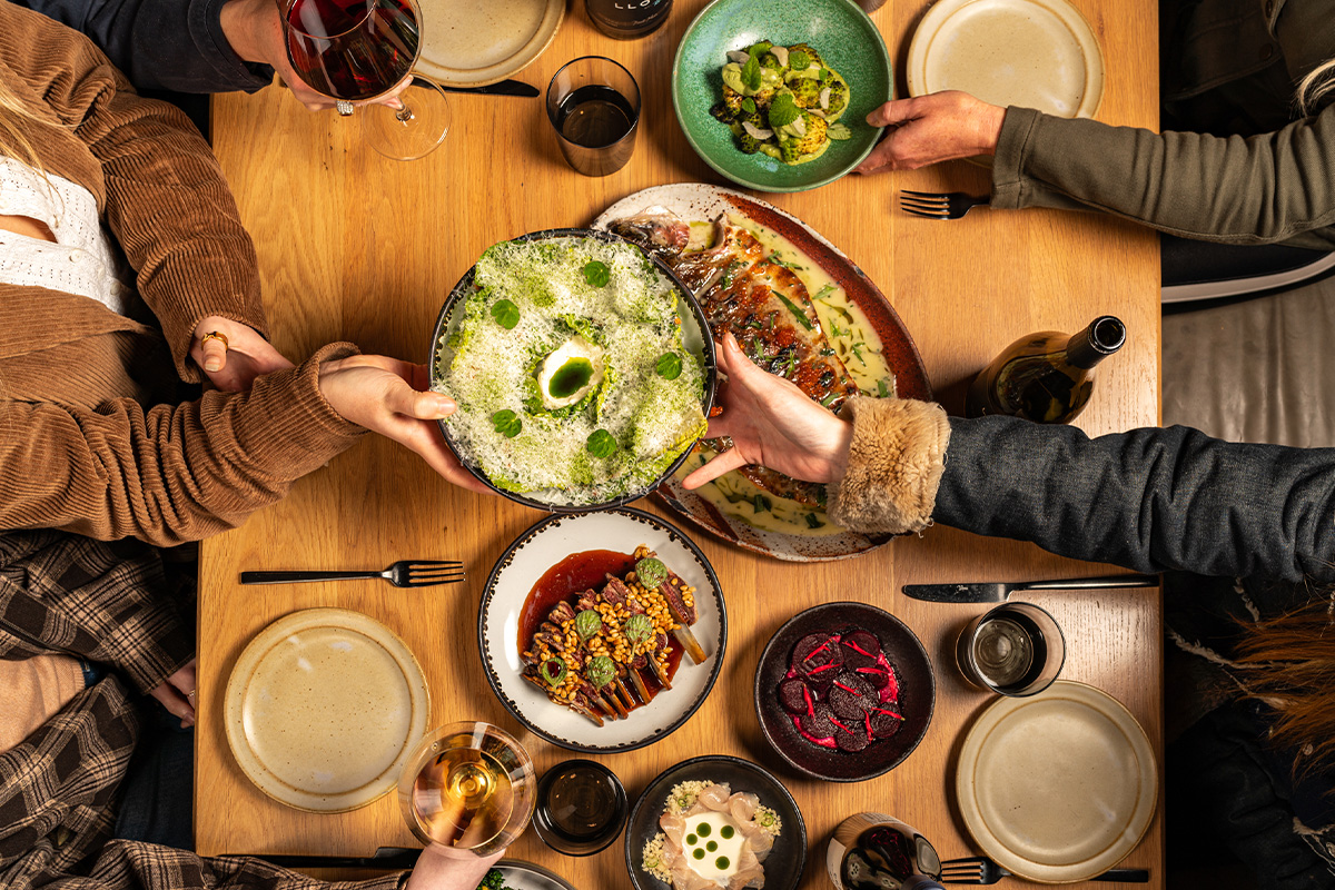 People enjoying wines around a dinner table.