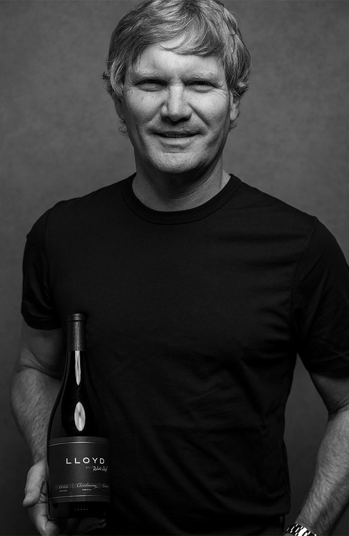 Picture of Rob Lloyd holding a bottle of Lloyd Chardonnay