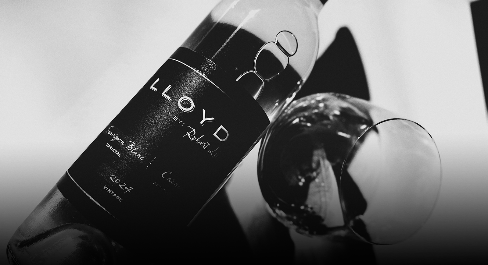 Black and white photo of Lloyd Sauvignon Blanc bottle with glass of wine