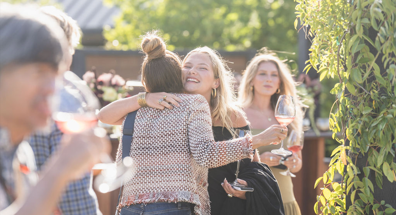 Photo of women greeting each other with a hug at the cocktail hour.