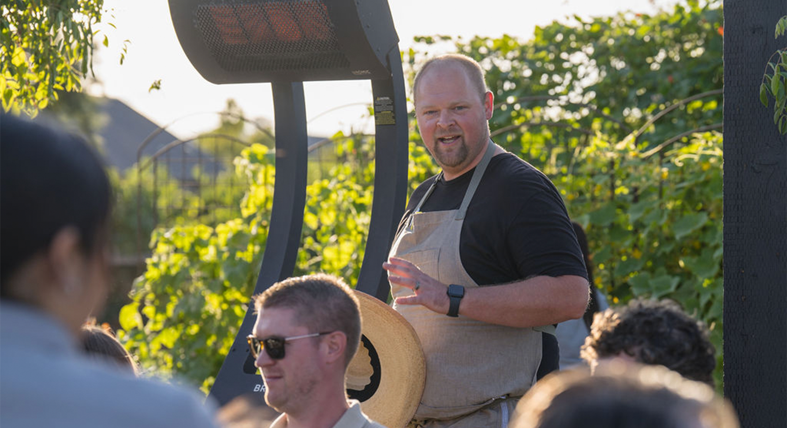Photo of Chef greeting the table of guests, introducing the meal that is about to be served.