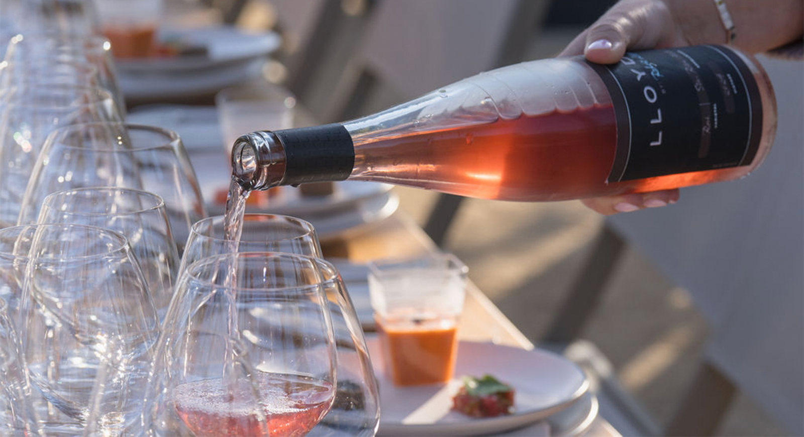 A photo of a glass of Lloyd Rosé being poured by the server.