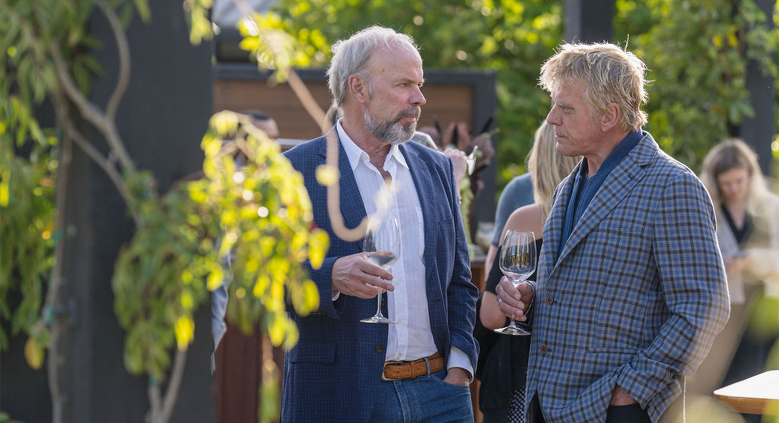 Men talking while drinking a glass of wine during the cocktail hour.